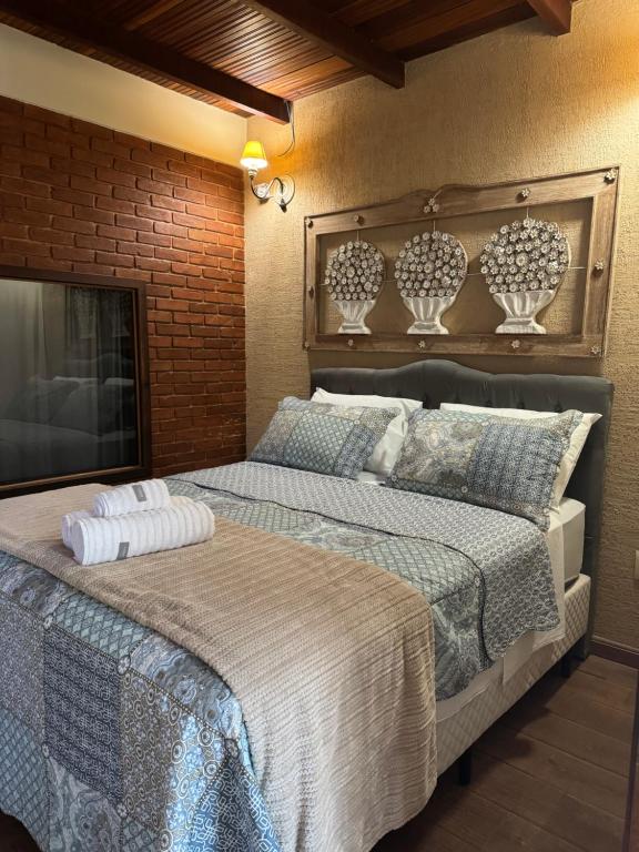 um quarto com uma cama grande com vasos na parede em Chalé 07 com cozinha para até 4 pessoas em Itatiaia