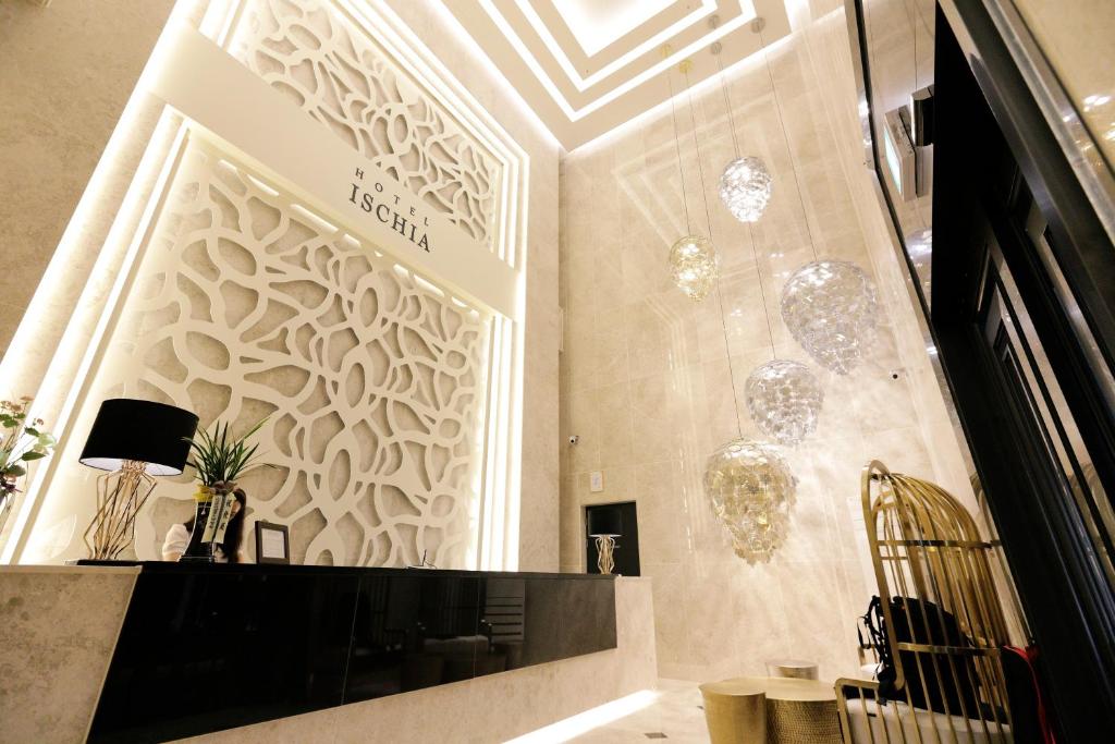 una hall con una parete con lampadari a braccio di Hotel Ischia a Yongin