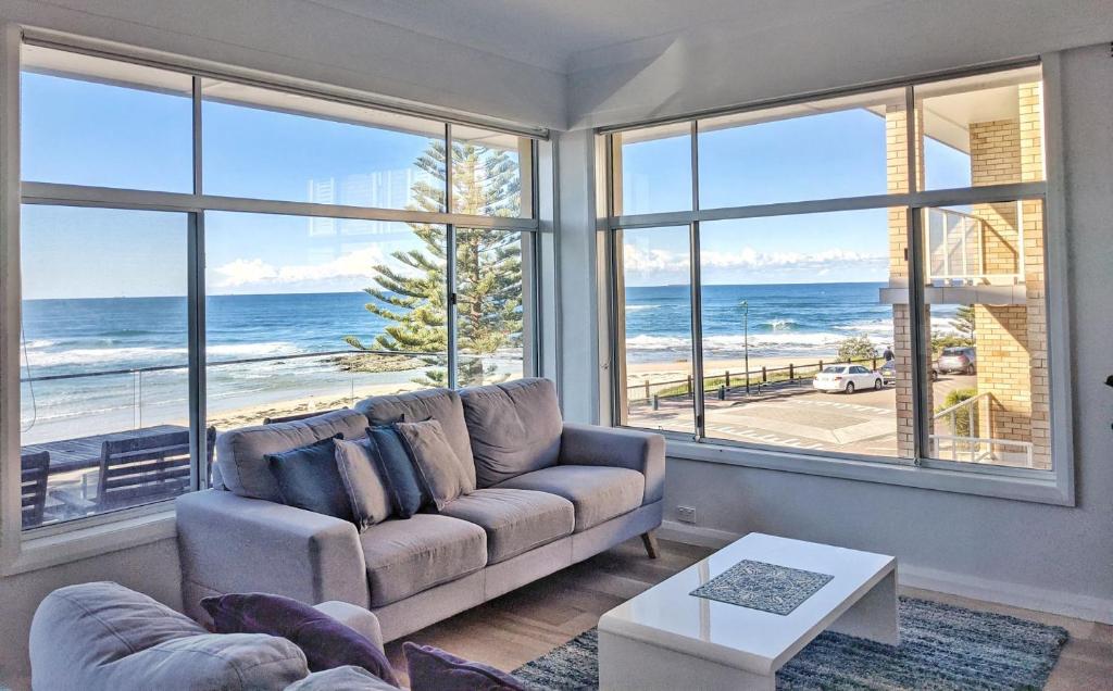 sala de estar con sofá y vistas al océano en Blue Pacific Apartment 8, en The Entrance