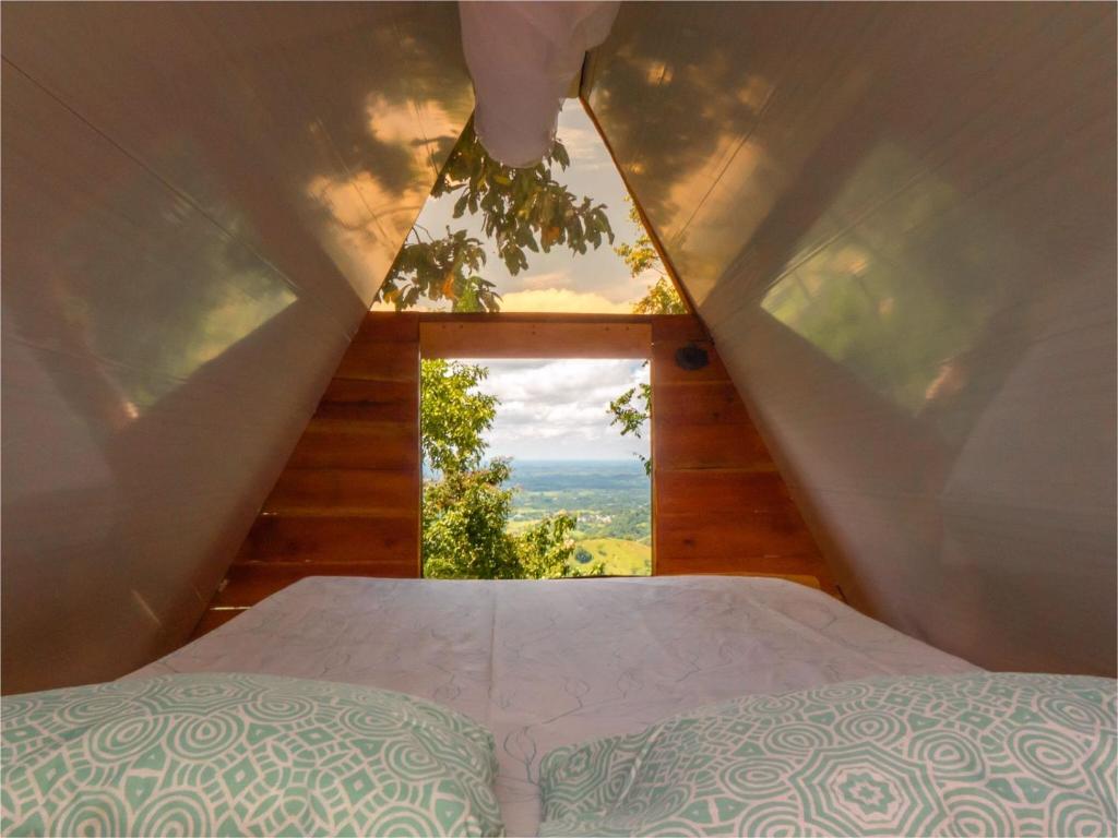 een bed in een kamer met een raam bij Tierras Munay in El Doncello