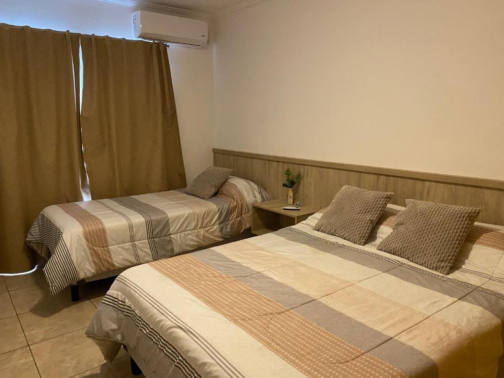 a hotel room with two beds and a window at Complejo Pampa 2 in Santa Rosa