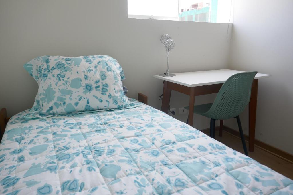 a bedroom with a bed with a table and a chair at LINDA HABITACION PRIVADA EN PUEBLO LIBRE in Lima