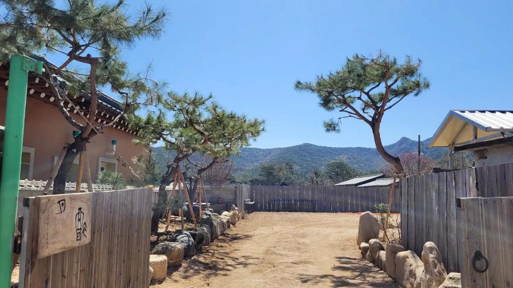 a fence in front of a house with trees at Stay Moon Charm in Gyeongju