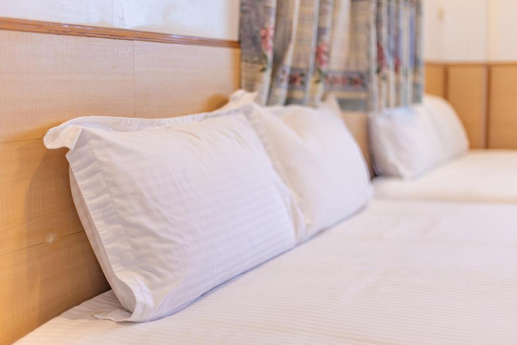 a bed with white pillows on top of it at Yishin Garden B&amp;B in Pinghe