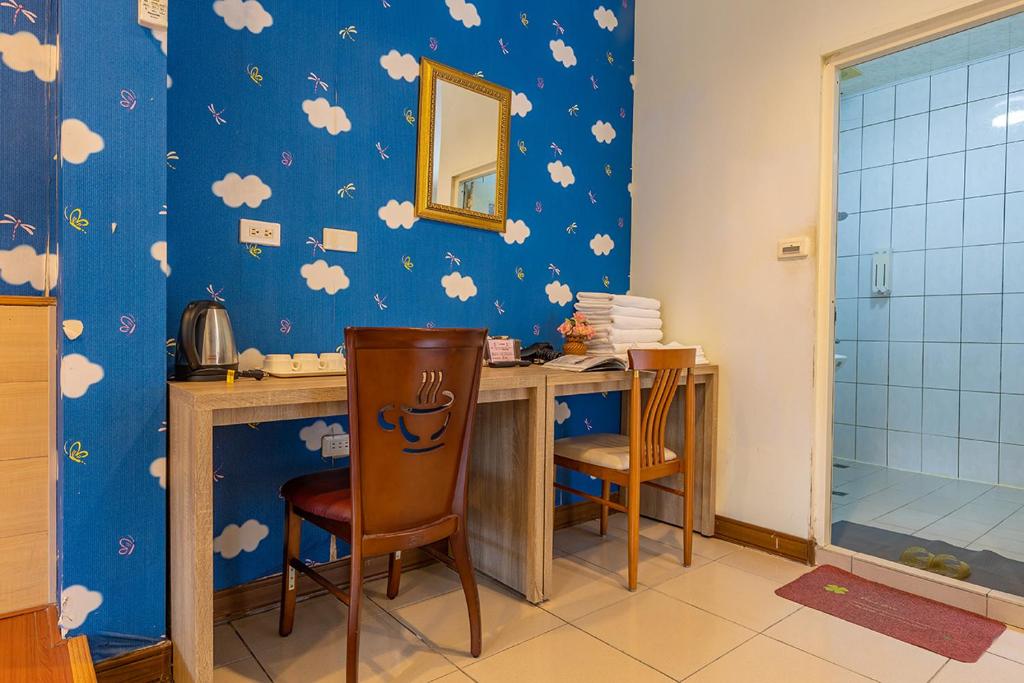 a room with a desk with chairs and a mirror at Yishin Garden B&amp;B in Pinghe