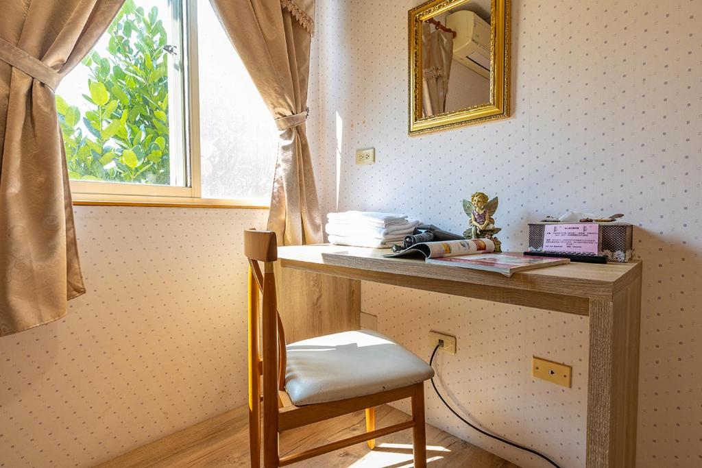 a desk in a room with a chair and a window at Yishin Garden B&amp;B in Pinghe