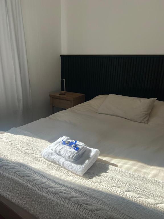 een witte handdoek bovenop een bed bij Acacia apartment in San Isidro