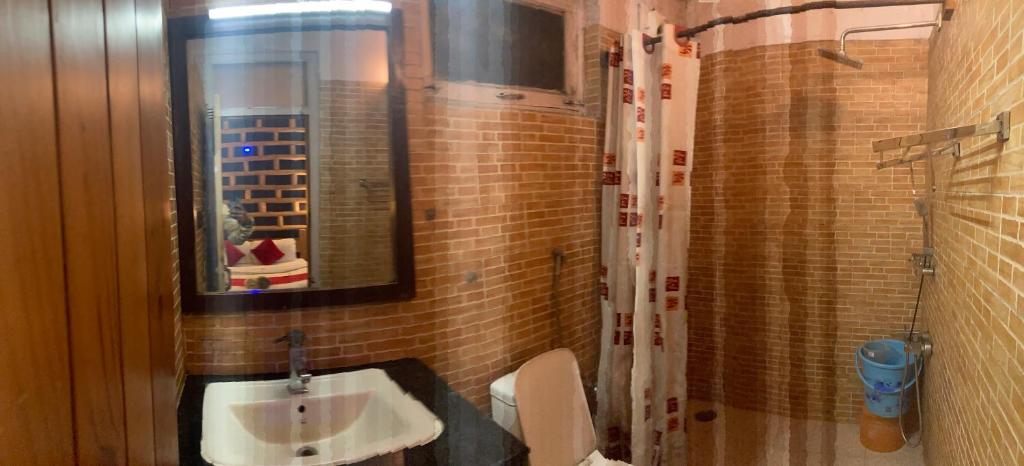 bagno con lavandino, servizi igienici e specchio di Swastik Royal Lodge a Junagadh