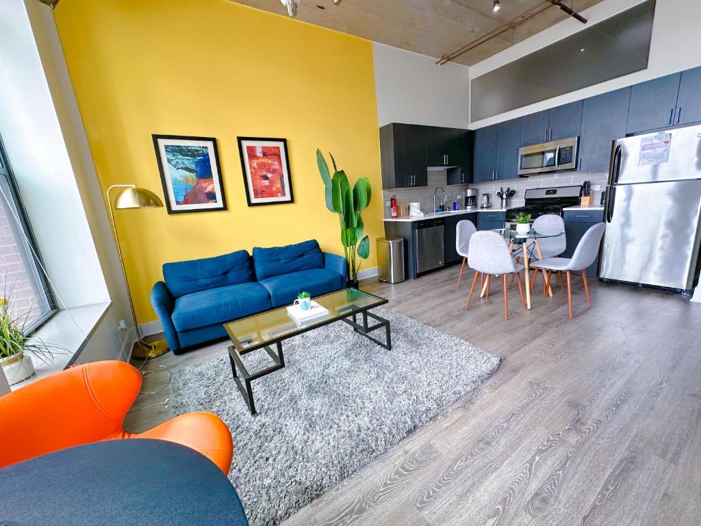 uma sala de estar com um sofá azul e uma cozinha em McCormick 2Br/2Ba family unit for up to 6 guests with Optional Parking & Gym access em Chicago