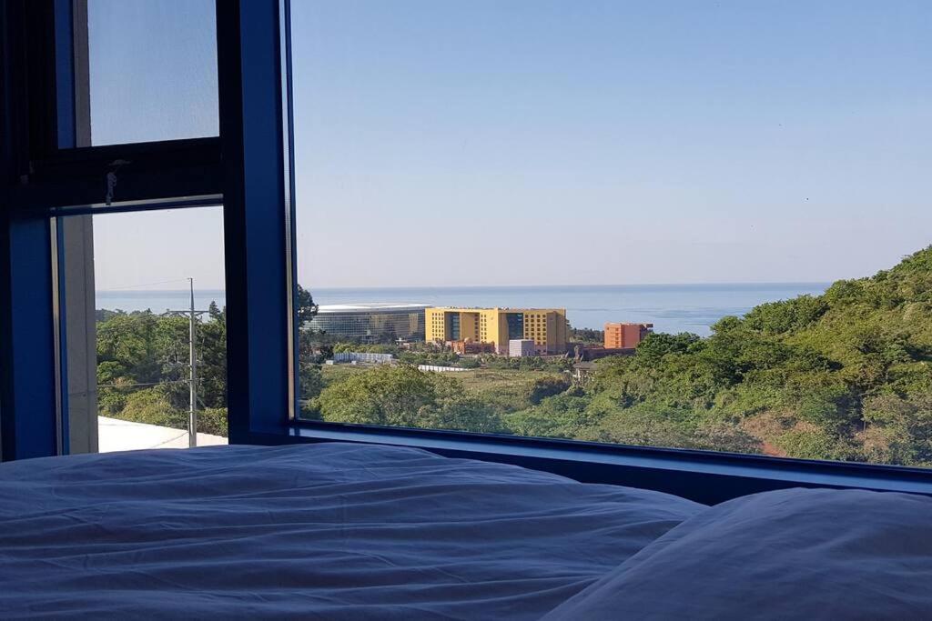 a bedroom with a bed and a view of the ocean at Ocean Cloud - Long term Stay in Seogwipo