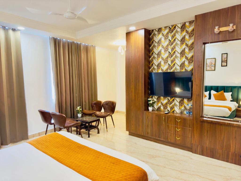 Habitación de hotel con cama y TV en Sanklap Hotel en Jamnagar