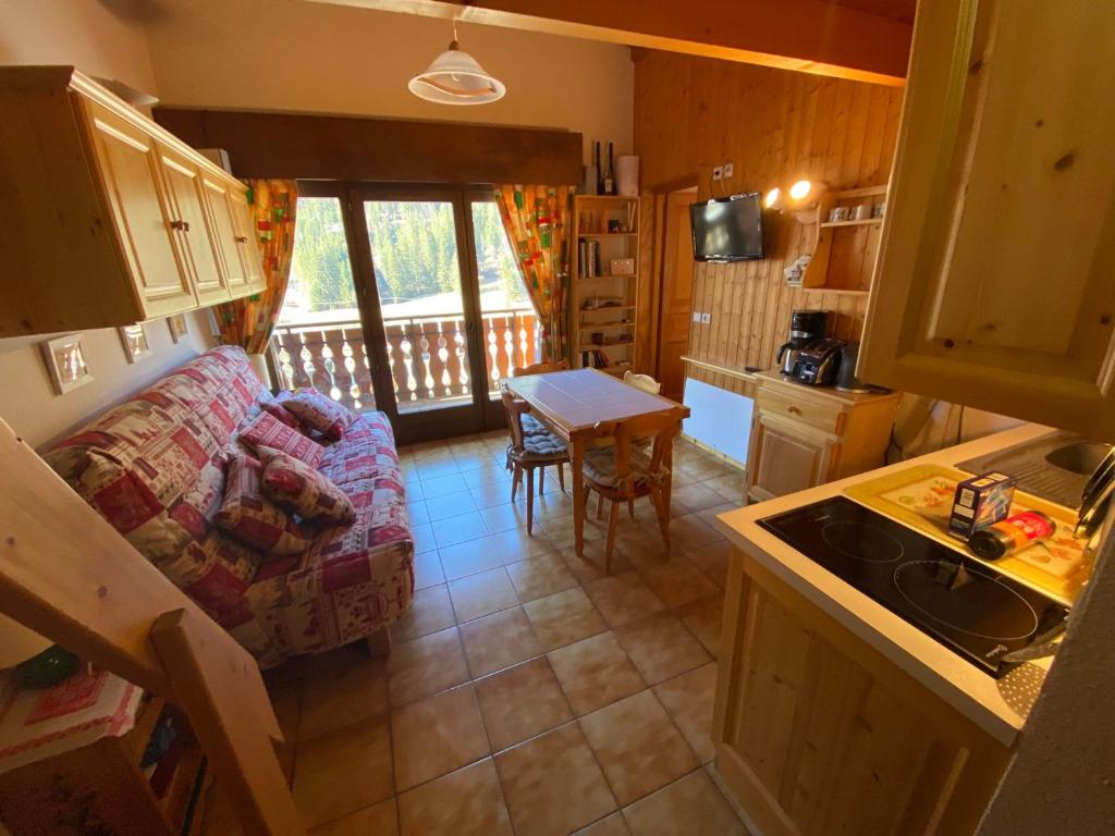 Il dispose d'une cuisine et d'un salon avec un canapé et une table. dans l'établissement Appartement Duplex Proche Centre Village et Télécabines à Châtel, Multi Pass à 3€/jour/personne! - FR-1-693-109, à Châtel