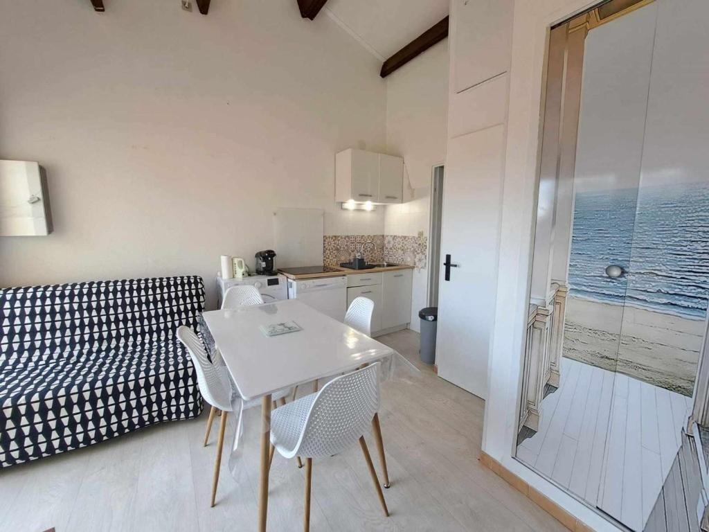 une cuisine et un salon avec une table et des chaises dans l'établissement Appartement lumineux avec terrasse, proche plage et commodités, Marseillan-Plage - FR-1-326-821, à Marseillan