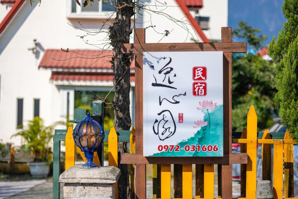 平和村的住宿－逸心園民宿，黄色栅栏前的标志