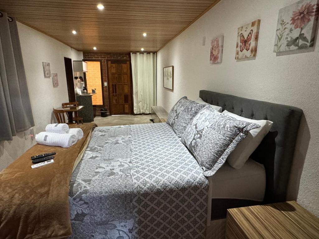 sypialnia z dużym łóżkiem z poduszkami w obiekcie Chalé 09 com cozinha no coração de penedo w mieście Itatiaia