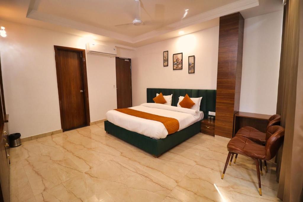 een hotelkamer met een bed en een stoel bij Sandhu Lodge in Jamnagar