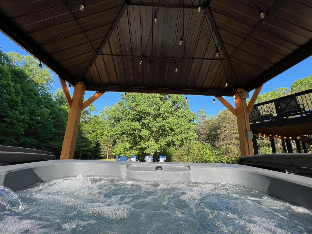 a hot tub in a gazebo with a roof at Hot Tub! Charming Cottage With Horse Farm View in Afton