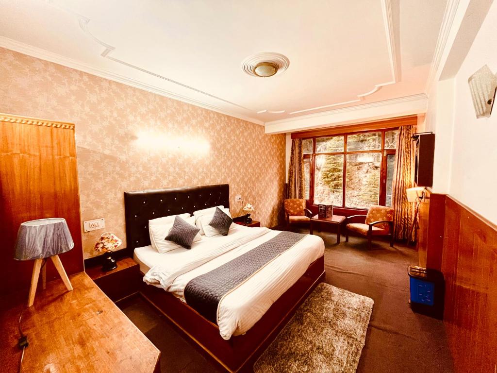 um quarto com uma cama grande num quarto em Happy Valley INN em Jamnagar