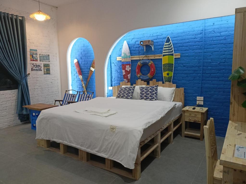 ein Schlafzimmer mit einem Bett und einer blauen Wand mit Surfbrettern in der Unterkunft Harbor Homestays in Hanoi