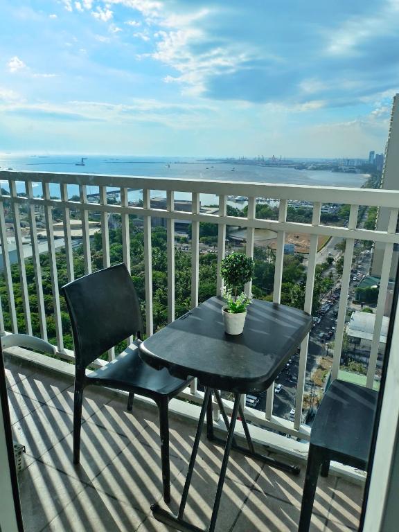 a table and chairs on a balcony with a view of the ocean at 2 Bedroom Condo SMDC Breeze Residences in Manila