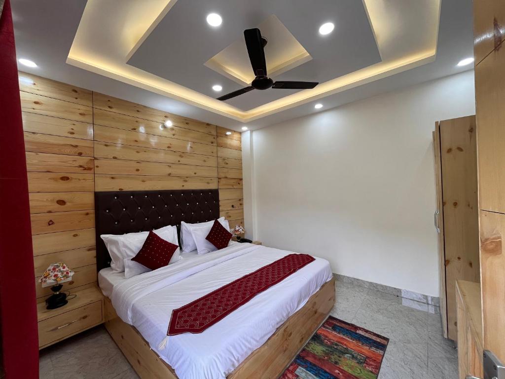 a bedroom with a large bed with a ceiling at Sharma Farms in Jamnagar