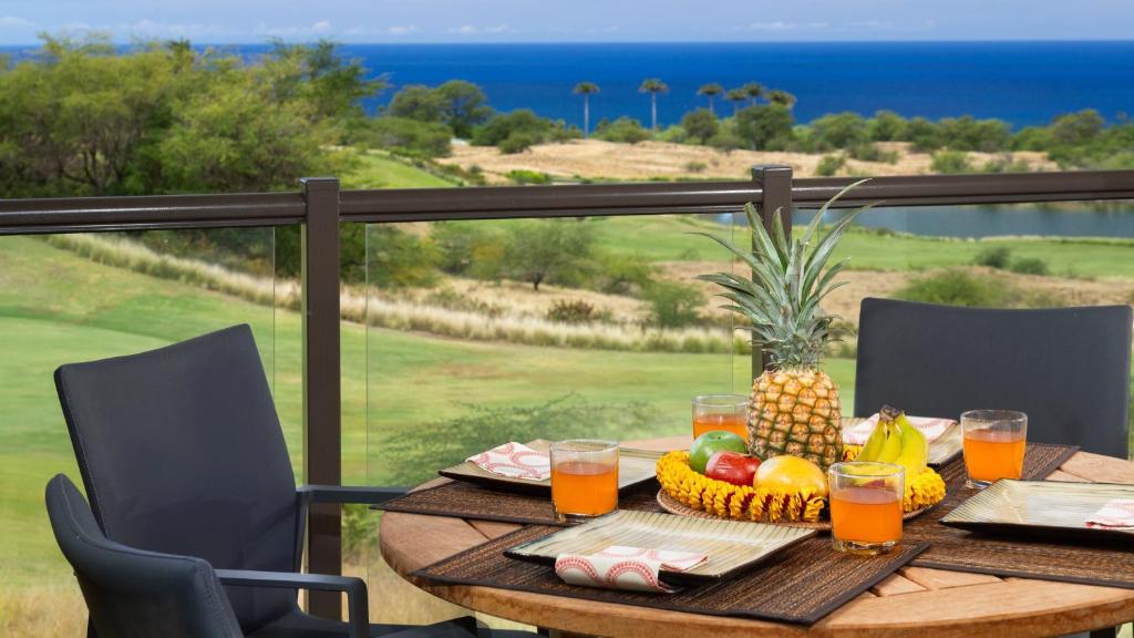 a table with fruit on a balcony with a view of the ocean at SUN RAY RETREAT Ocean Sunsets Views Optional Mauna Kea Hotel Privileges in Waimea