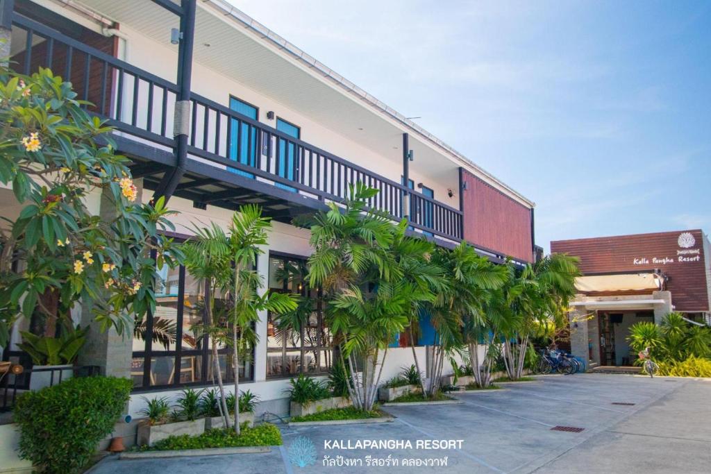 un edificio con palmeras delante en Kallapangha Resort Khlongwan, en Klong Wan