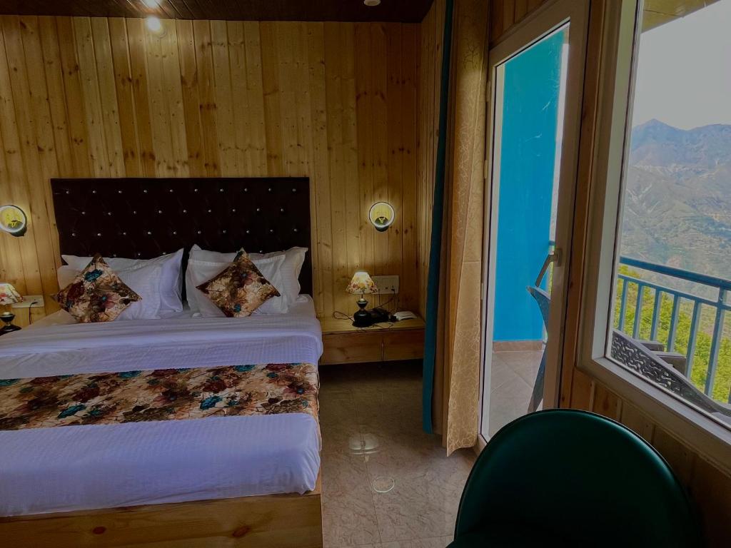 a bedroom with a bed and a large window at Bhupesh Lodge in Rajkot