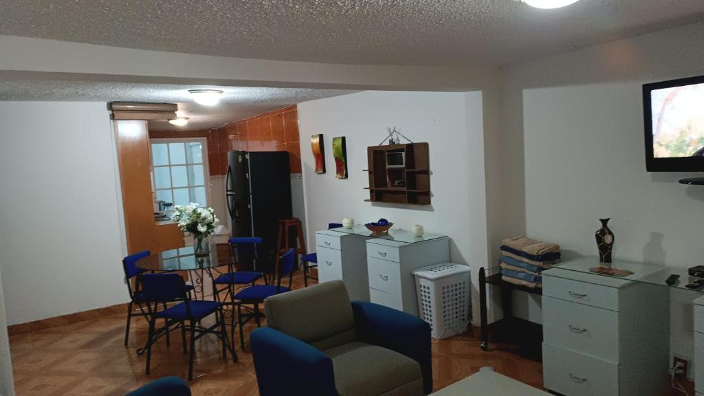 ein Wohnzimmer mit einem Tisch und Stühlen sowie eine Küche in der Unterkunft Las flores Boulevard in Mexiko-Stadt