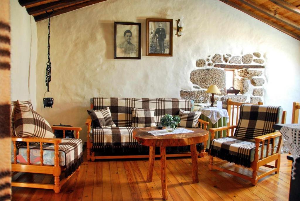 a living room with couches and a table at Casa do Forno in Valezim
