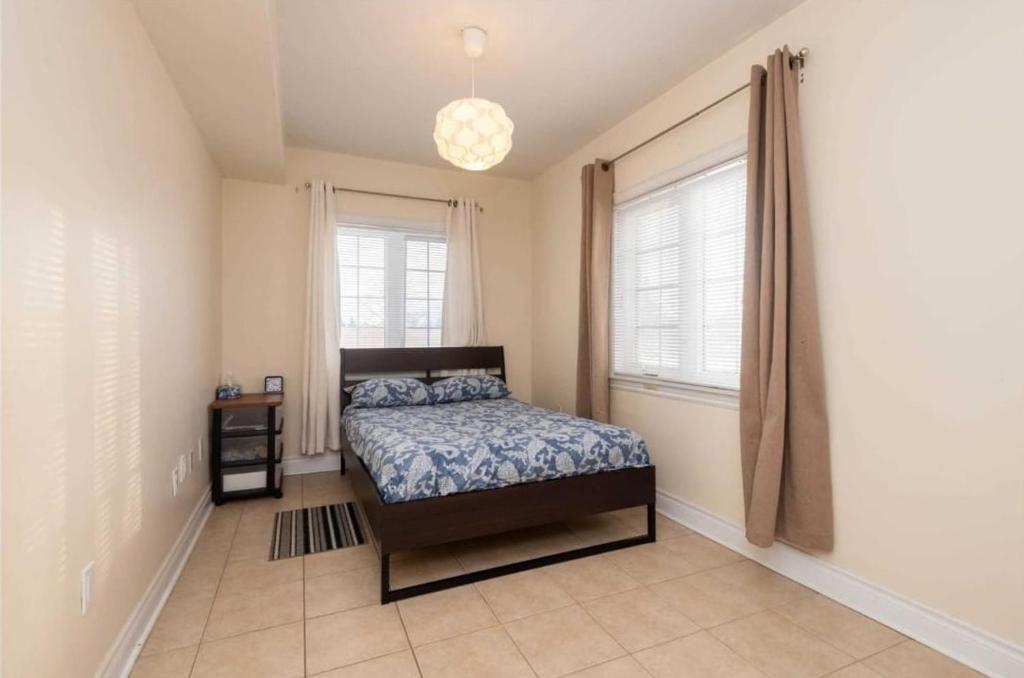 een slaapkamer met een bed en een raam bij Jazzy Apartment in Mississauga