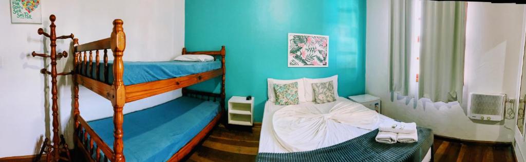 2 beliches num quarto com paredes azuis em Pousada Beluga em Búzios