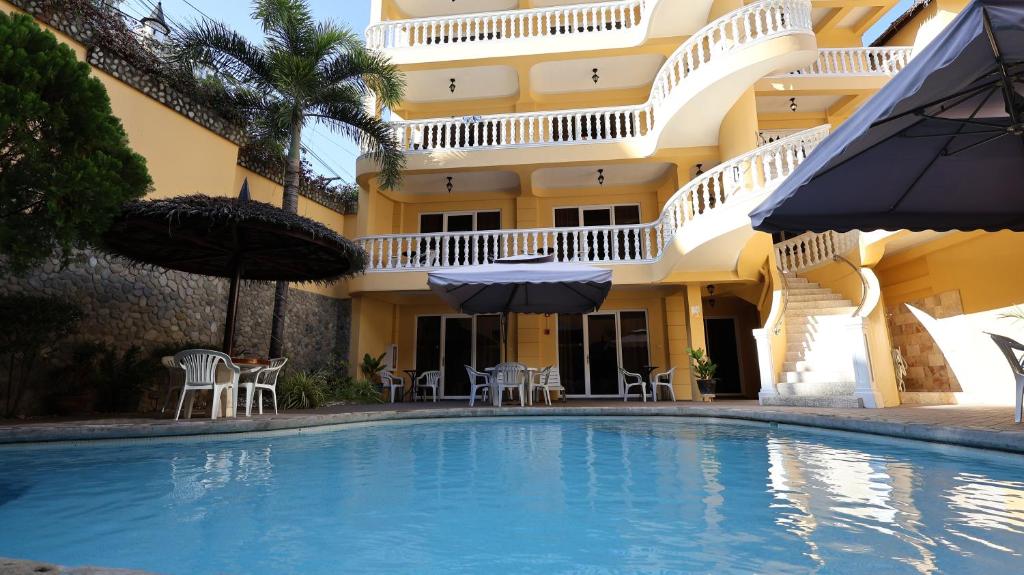 un hôtel avec une piscine en face d'un bâtiment dans l'établissement Mermaid Resort and Dive Center, à Puerto Galera