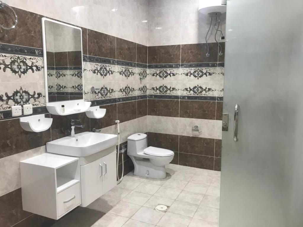 uma casa de banho com um WC, um lavatório e um espelho. em Moonlight em Taif