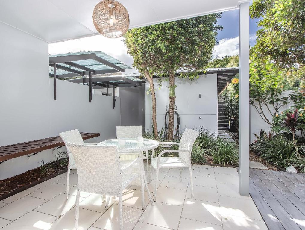 ein weißer Esstisch und Stühle auf einer Terrasse in der Unterkunft Stunning She Oak Lane - 2 Bedroom Apartment! in Casuarina