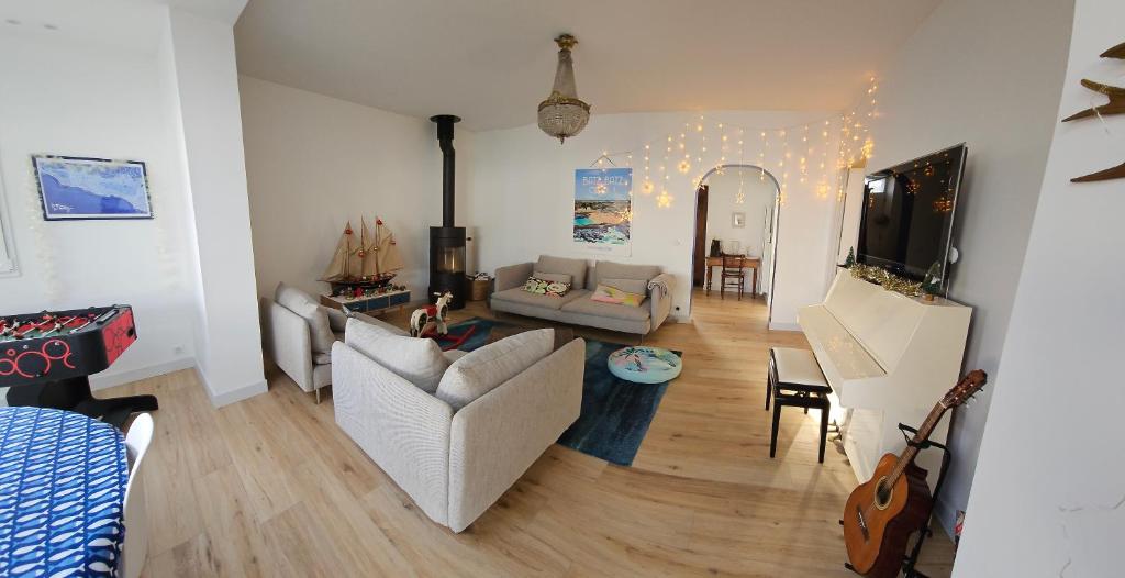 - un salon avec un canapé et une table dans l'établissement Maison Familiale et Maisonnette avec jardin et cabine de plage, 8min à pieds des plages, à Batz-sur-Mer