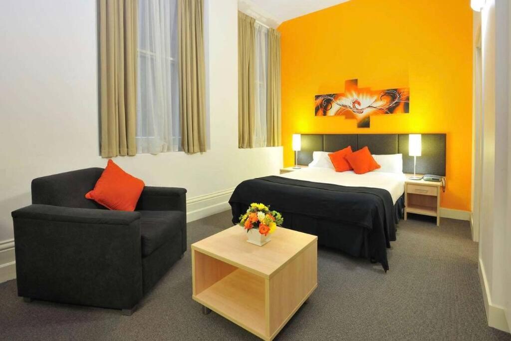 een hotelkamer met een bed en een stoel bij Melbourne boutique hotel in Melbourne