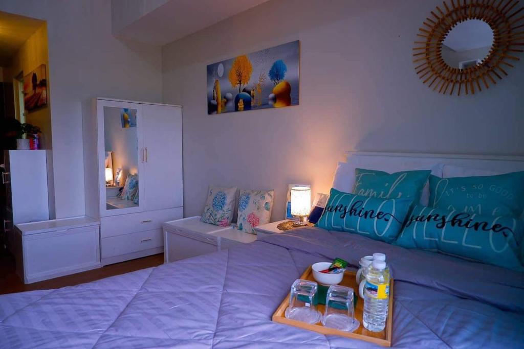 卡加延德奧羅的住宿－S&S Condostay，一间卧室配有一张床和一瓶水
