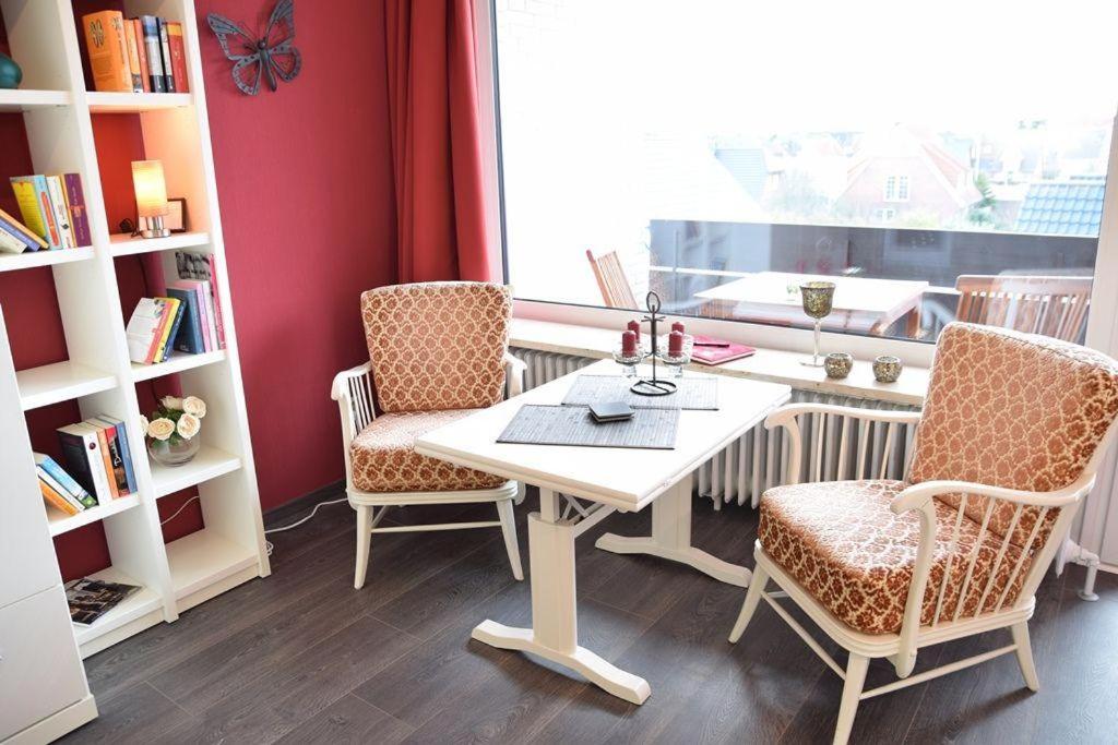 - une table et des chaises dans une chambre avec fenêtre dans l'établissement Krabbenliebe, à Westerland