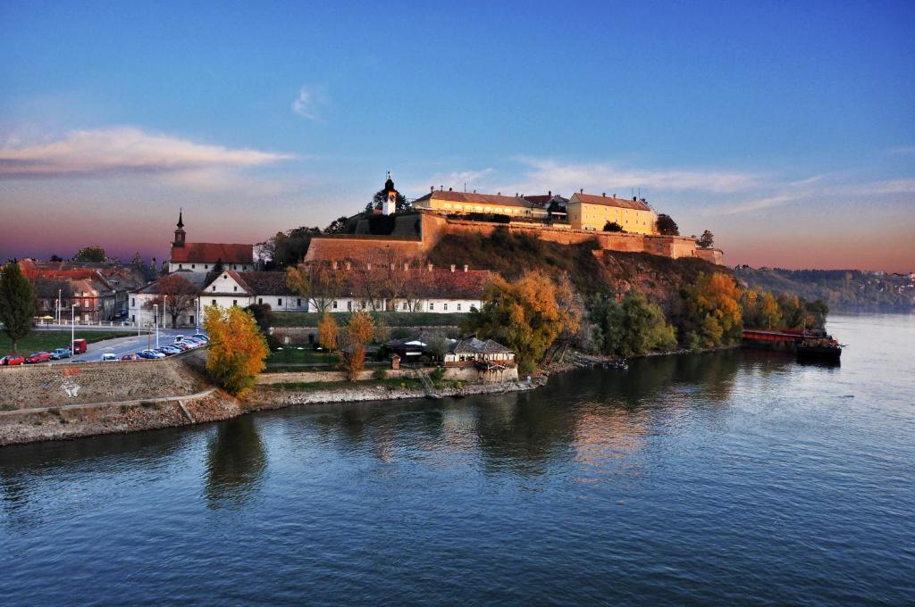 un château au sommet d'une colline à côté d'une rivière dans l'établissement Garni Hotel Leopold I, à Novi Sad