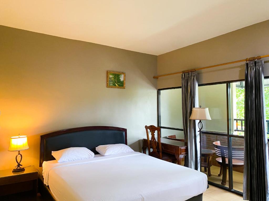 Perabumulih的住宿－中央城旅館，一间卧室配有一张床、一张桌子和一个窗户。