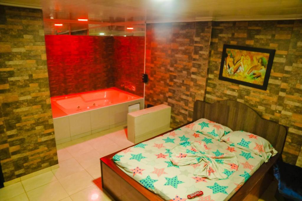 y baño con cama y bañera. en Hotel Residencial Olaya Plaza, en Manizales