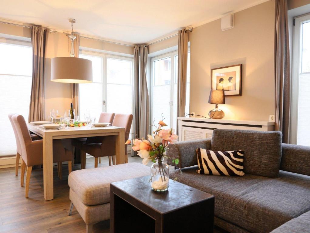 ein Wohnzimmer mit einem Sofa und einem Tisch in der Unterkunft Ferienhaus mit neuen und sehr hochwertigen Appartements in zentraler Lage in Westerland in Westerland