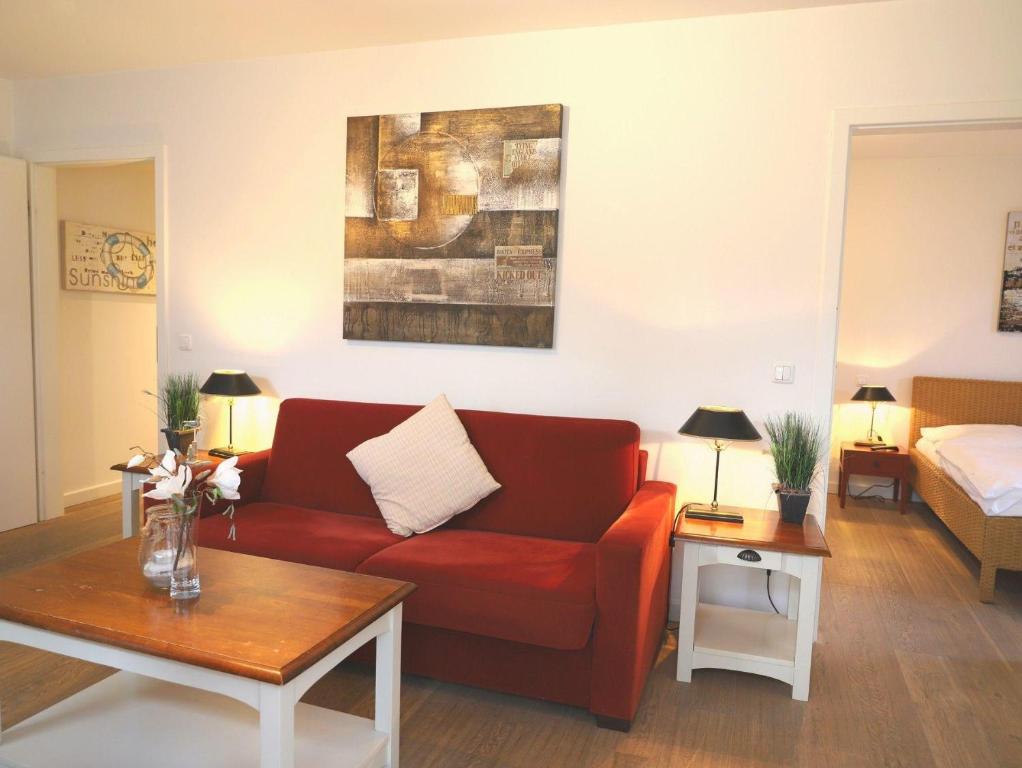 - un salon avec un canapé rouge et un lit dans l'établissement Viktoriastraße 6, Whg.7, V.-Residenz, à Westerland