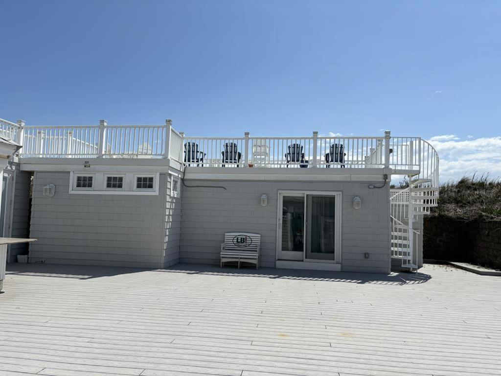 a white house with a deck and a balcony at Oceanfront Adorable Cottage! Perfect For A Couple Or Small Family Of 4! in Ship Bottom