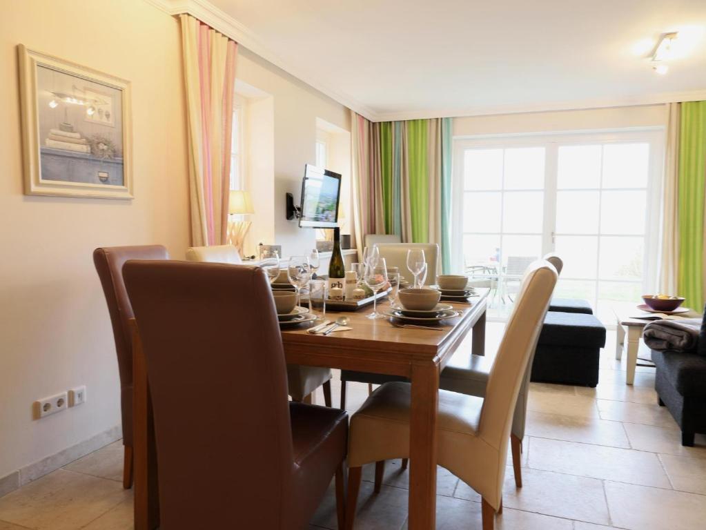 - une salle à manger avec une table et des chaises en bois dans l'établissement Am Loo 8b, List, à List auf Sylt