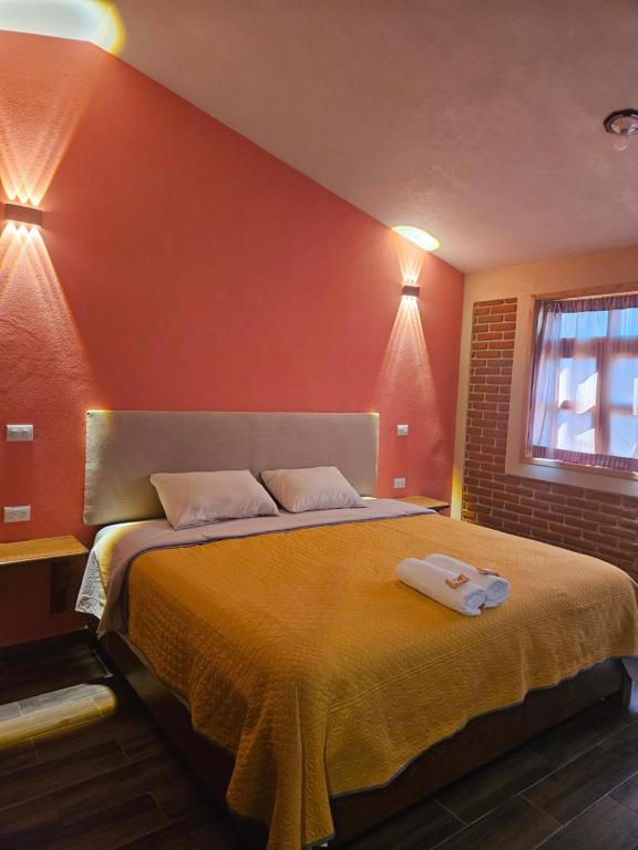 Un dormitorio con una cama grande con paredes naranjas. en Gardenias 4, en Zacatlán