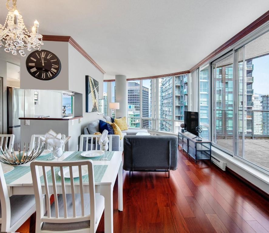 a kitchen and dining room with a clock on the wall at Designer sub-penthouse - Central Downtown Views And King Bed! in Vancouver