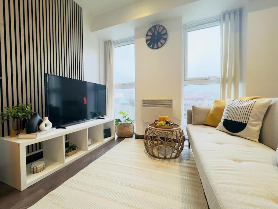 Una sala de estar con un sofá y un televisor de pantalla plana. en Central Luton Apartment, en Luton