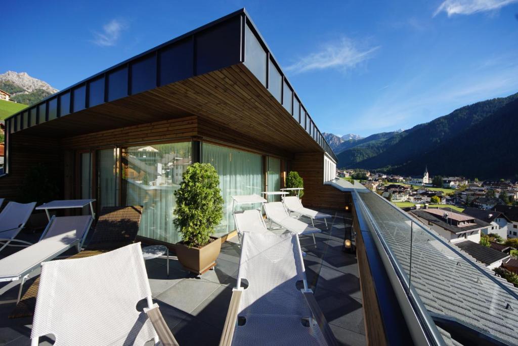 un balcone di una casa con sedie e montagne di Residence Plan De Corones a San Vigilio Di Marebbe